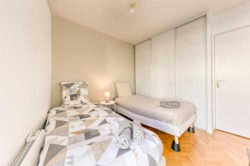 马西Bright & Chill - Terrasse - À 7 min Gare Massy TGV的一间卧室配有两张床和一张小桌子