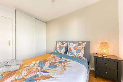 马西Bright & Chill - Terrasse - À 7 min Gare Massy TGV的一间卧室配有一张床,床头柜上配有一盏灯