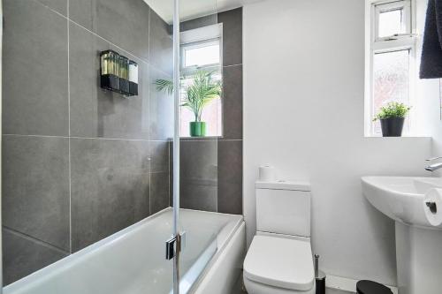 a bathroom with a tub and a toilet and a sink at Stylish Studio Apt in Leeds in Headingley