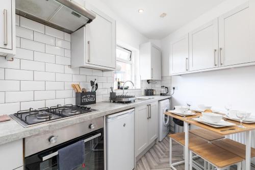 a kitchen with white cabinets and a stove top oven at Stylish Studio Apt in Leeds in Headingley
