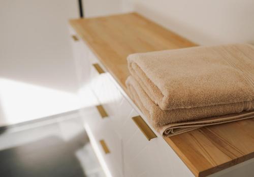 deux serviettes posées sur un comptoir en bois dans l'établissement Schöne Designer-Wohnung im Mangfalltal, à Bruckmühl