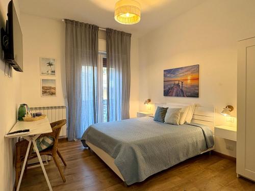 a bedroom with a bed and a table and a desk at Favola Guesthouse Affittacamere in Nettuno