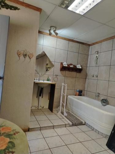 une salle de bains avec baignoire et lavabo dans l'établissement Droombos Guestrooms, à Kuruman
