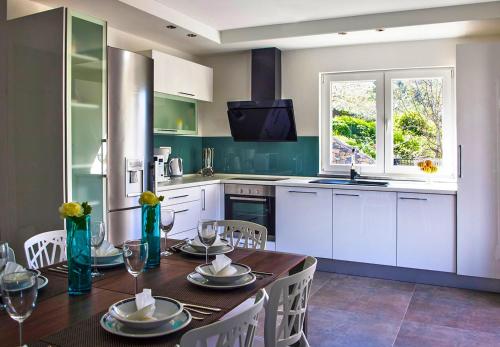 a kitchen with a table with chairs and a dining room at Villa Mosor Mit Beheiztem Salzwasserpool Und Sauna in Omiš