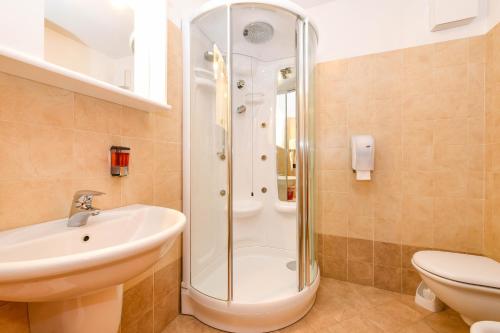 Un baño con ducha, lavabo e inodoro. en Hotel Bleis, en Ponte di Legno