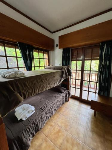 2 Etagenbetten in einem Zimmer mit Fenstern in der Unterkunft Villa Marta Casa de Campo in San Lorenzo