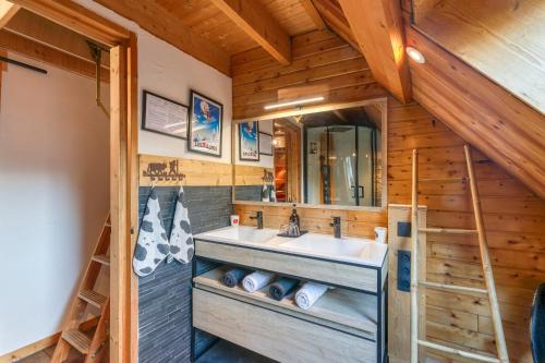 une salle de bain avec un lavabo et un miroir dans l'établissement Le Cosy Lodge, à Le Bourg d'oisans
