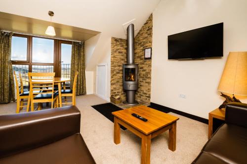 - un salon avec un canapé et un poêle à bois dans l'établissement Grand Villa Heights, à Ravenscar