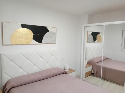 a bedroom with two beds and a mirror at El Rincon de Riera in Pola de Lena