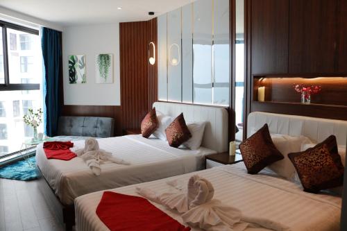 two beds in a hotel room with towels on them at Apec Mui Ne Chill Sea View in Ấp Thiẹn Ái