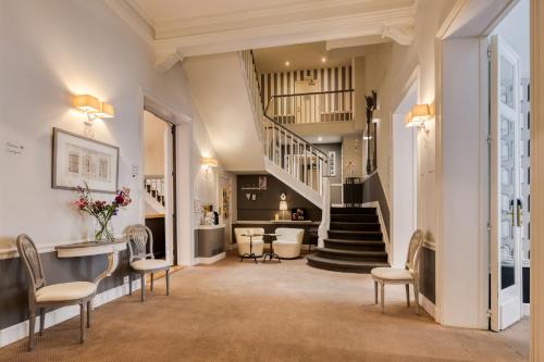 a large living room with a staircase and chairs at Hotel Made In Louise in Brussels