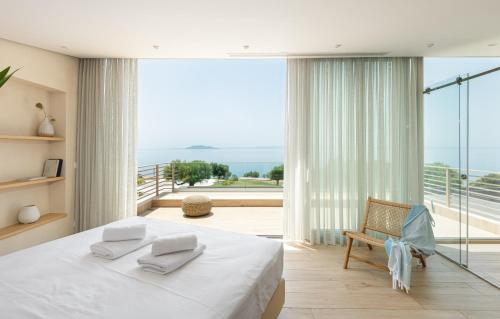 ein Schlafzimmer mit einem großen weißen Bett und einem Balkon in der Unterkunft Luria Homes in Lagomandra