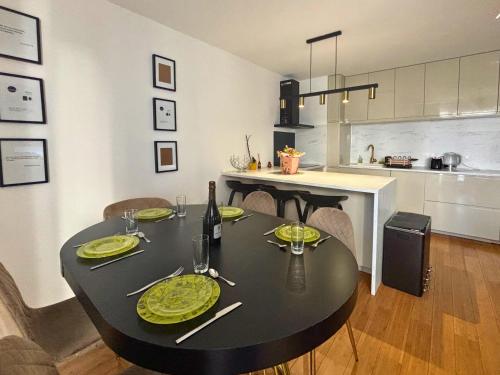 une table de salle à manger avec une table noire et une cuisine dans l'établissement Bezons Golden - 3 chambres - 3min du Tramway #SirDest, à Bezons