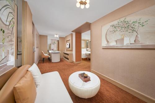 ein Hotelzimmer mit einem Bett und einem Wohnzimmer in der Unterkunft Nanyang King's Gate Hotel--Free Shuttle Service to Canton Fair in Guangzhou