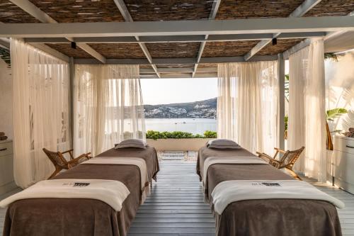 a row of beds in a room with a window at Cape Bodrum Luxury Hotel & Beach in Gundogan