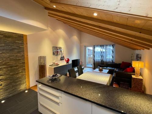 采尔马特Penthouse Matterhorn Vista的厨房和带沙发的客厅