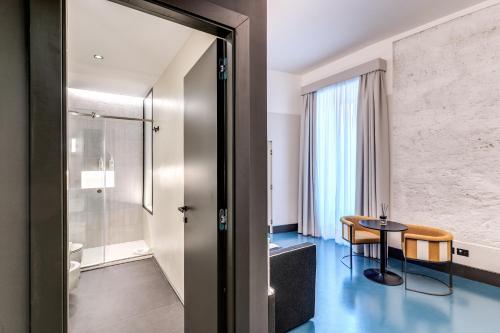 ein Hotelzimmer mit einem Tisch und einem Bad in der Unterkunft Adaram Suites in Neapel