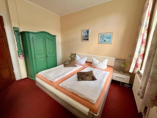 - une chambre avec un lit et une porte verte dans l'établissement Villa HarzFokus - #Hotel#Pension#Frühstück, à Wernigerode
