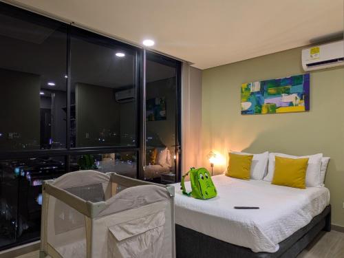 ein Schlafzimmer mit einem Bett mit grüner Tasche drauf in der Unterkunft Bizsar Natural - Aire Acondicionado - 2 Increíbles Terrazas - BBQ in Ibagué