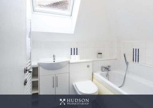 a bathroom with a sink and a toilet and a bath tub at Home with Rear Terrace in Ironbridge in Ironbridge