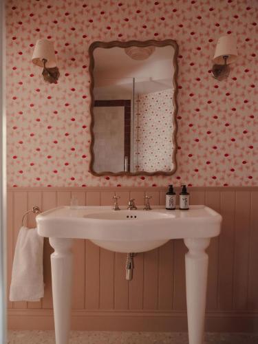 a bathroom with a white sink and a mirror at Luxury Apartment with Roof Terrace - Cotswolds in Stow on the Wold