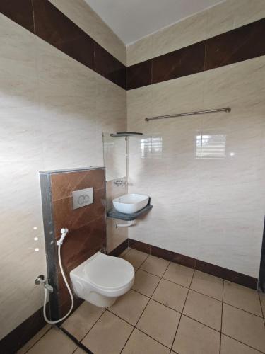 a bathroom with a toilet and a sink at Vasant Vihar Farm House in Silvassa