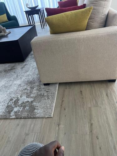 een woonkamer met een bank en houten vloeren bij NK Plaza in Nairobi