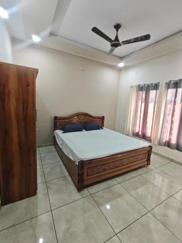 a bedroom with a bed and a ceiling fan at Vasant Vihar Farm House in Silvassa