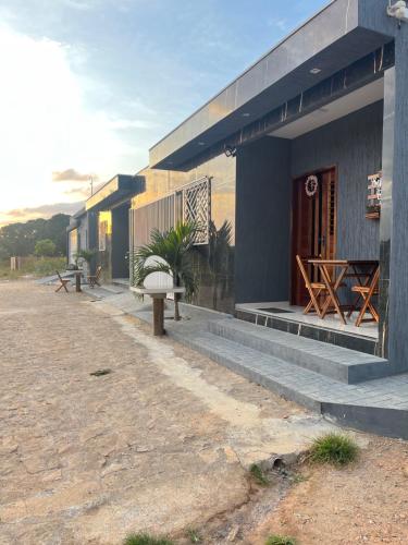 ein Gebäude mit Bänken und Tischen außerhalb in der Unterkunft Casa de Serra 02 em Viçosa do Ceará in Viçosa do Ceará