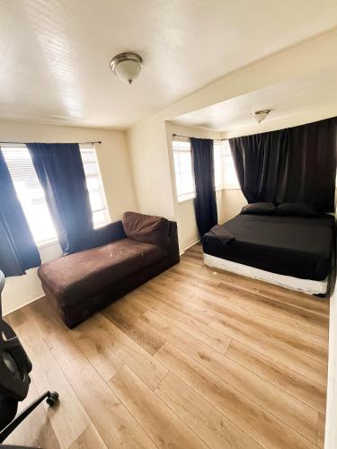 a bedroom with a bed and a couch in it at Van Nuys Homes for the Soul in Los Angeles