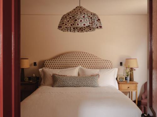 a bedroom with a white bed with a chandelier at Luxury Apartment with Roof Terrace - Cotswolds in Stow on the Wold
