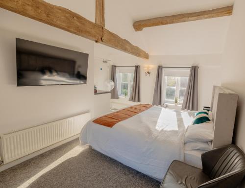 a bedroom with a large bed and a tv at Ye Olde Original Withy Trees in Bamber Bridge