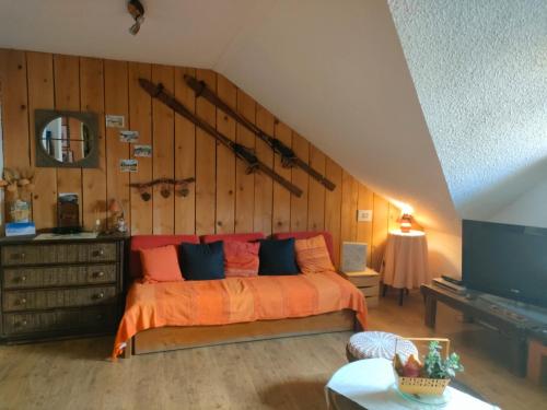 sypialnia z łóżkiem z pomarańczową pościelą i niebieskimi poduszkami w obiekcie L'Edelweiss w mieście Saint-Pierre-de-Chartreuse