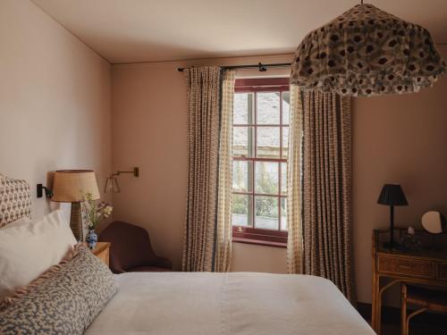 ein Schlafzimmer mit einem Bett und einem Fenster in der Unterkunft Luxury Apartment with Roof Terrace - Cotswolds in Stow on the Wold