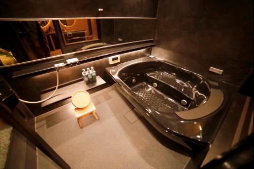 ein Badezimmer mit Badewanne und kleinem Hocker in der Unterkunft Osakaya Hotel & SAUNA in Kaizuka