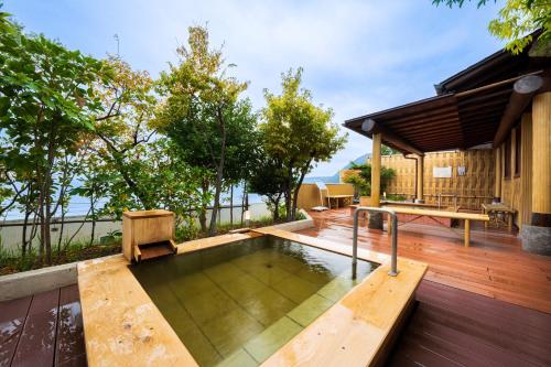 a swimming pool on a deck with a house at Seaside Hotel Mimatsu Ooetei in Beppu