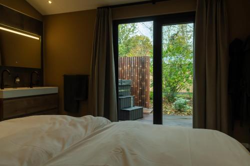 a bedroom with a bed and a sliding glass door at Rijn Residentie in Alphen aan den Rijn