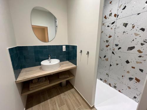 Chez Louise et Léo في إج مورت: حمام مزود بحوض ومِرآة