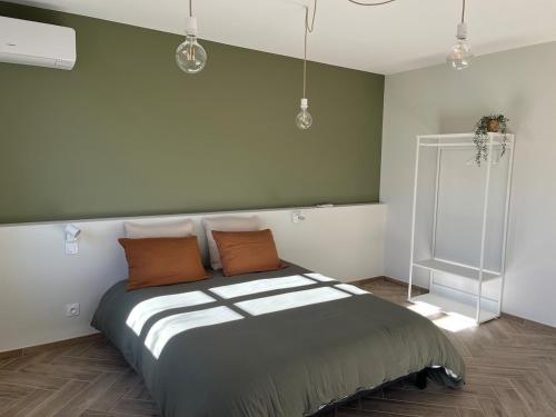 a bedroom with a large bed with orange pillows at Chez Louise et Léo in Aigues-Mortes