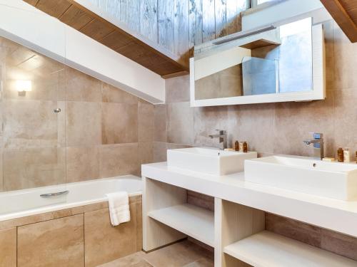 une salle de bain avec deux lavabos et une baignoire dans l'établissement Luxueux appartement 4 pièces au cœur de Courchevel Village, à proximité des pistes et commerces - FR-1-562-32, à Courchevel