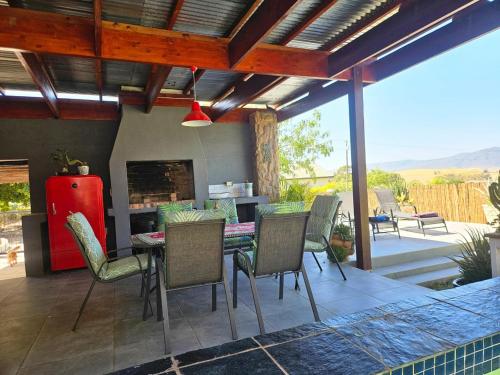 a patio with a table and chairs and a red refrigerator at The Homestead at Koringberg Country Cottages in Koringberg