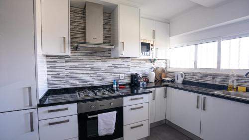 a kitchen with white cabinets and a stove top oven at KS near the airport in Lisbon
