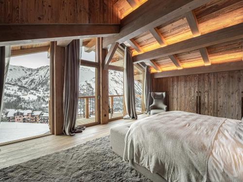 a bedroom with a large bed with a mountain view at Chalet skis aux pieds avec bain nordique, 12/14 pers, chef inclus - FR-1-570-3 in Saint-Martin-de-Belleville