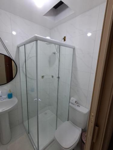a bathroom with a shower and a toilet and a sink at Hospedaria Casa da Lia in Mucugê
