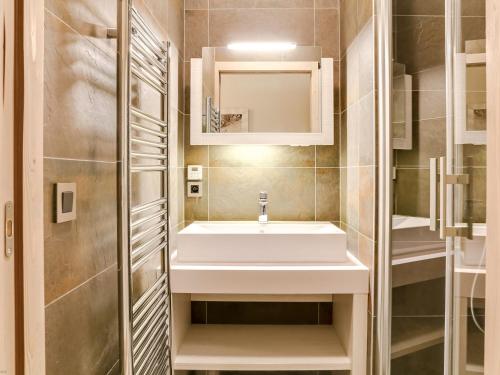 une salle de bains avec un lavabo blanc et un miroir dans l'établissement Appartement Contemporain à Courchevel Village, 4 Chambres, Proche Pistes, Sauna et Parking - FR-1-562-13, à Courchevel