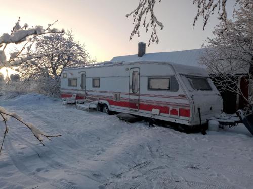 a red and white rv parked in the snow at Tornio caravan in Tornio