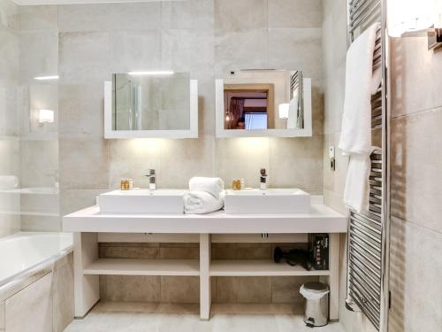 ein weißes Badezimmer mit Waschbecken und Spiegel in der Unterkunft Appartement 4 pièces de luxe, à deux pas des pistes et commerces, avec parking et accès fitness à Courchevel - FR-1-562-35 in Courchevel