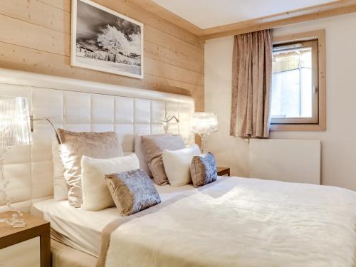 une chambre avec un grand lit blanc avec des oreillers dans l'établissement Appartement moderne avec WiFi et parking sous-terrain à Courchevel Village - FR-1-562-28, à Courchevel