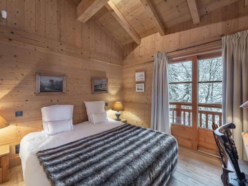 une chambre avec un lit dans une cabane en rondins dans l'établissement Chalet familial à Courchevel, proche centre et pistes, avec sauna et jacuzzi - FR-1-562-54, à Courchevel