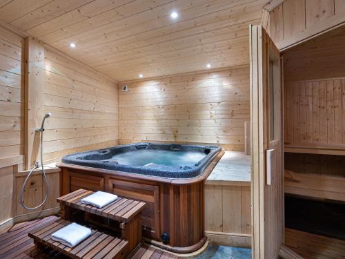 une baignoire jacuzzi dans une pièce en bois dans l'établissement Chalet montagnard à Rochebrune avec jacuzzi, sauna, 6 chambres, proche des pistes, accueil 12 pers - FR-1-569-37, à Megève